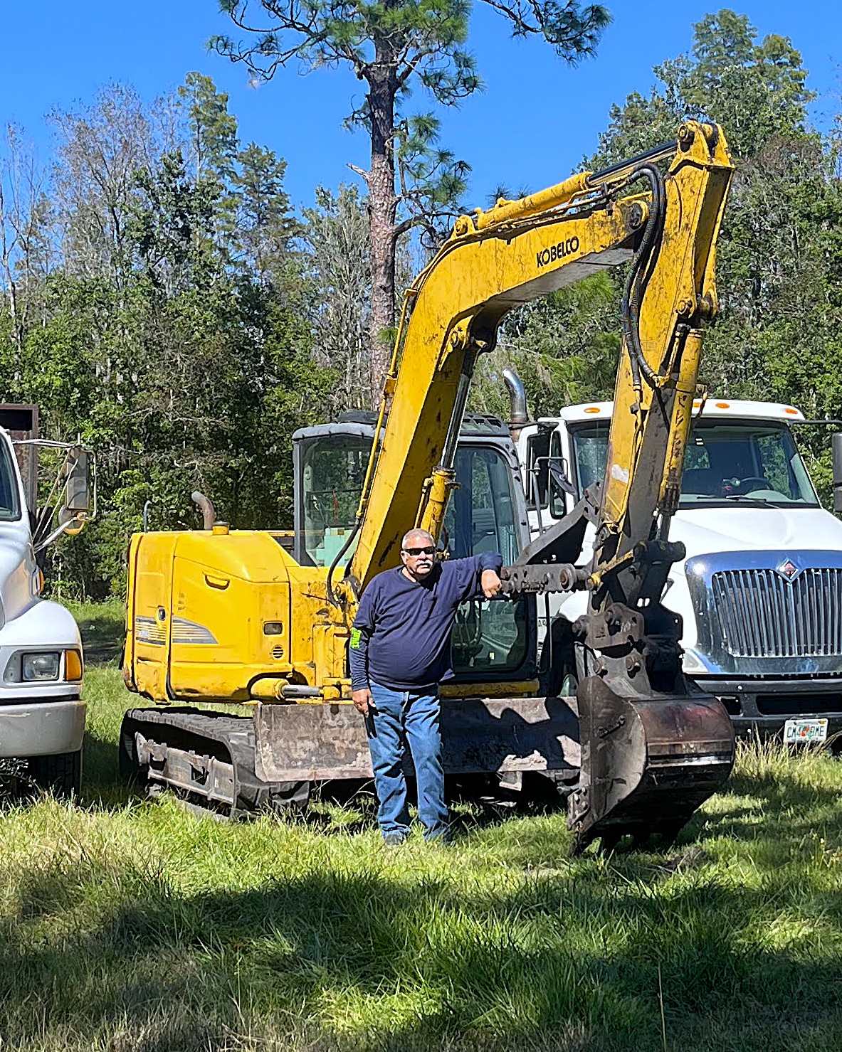 Father-and-son crew with excavator and haul trucks